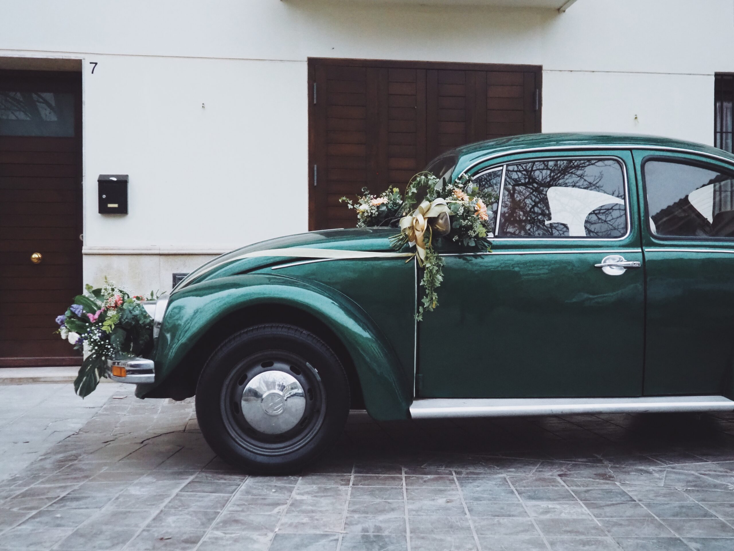 Perfil lateral del VW Escarabajo verde con decoración nupcial dorada
