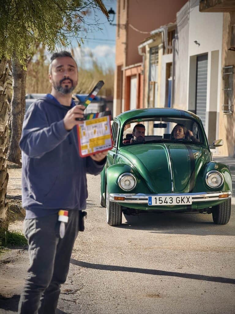 Rodaje de serie de televisión con el VW Escarabajo verde de 600 Veces Sí en Valencia, claqueta y actores dentro del coche clásico