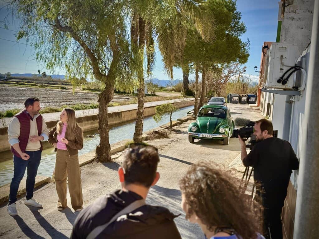 Equipo de producción audiovisual filmando una serie de televisión con el VW Escarabajo verde en exteriores de Valencia