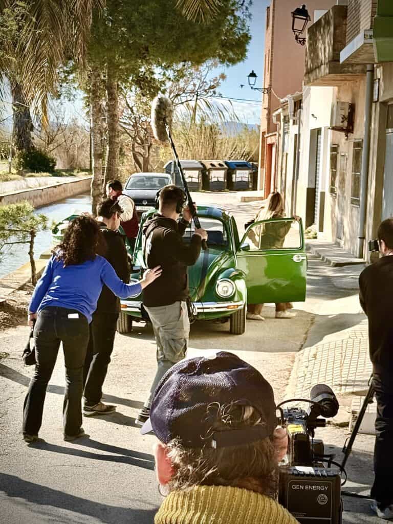 Equipo completo de producción audiovisual con cámara y micro de pértiga rodando con el VW Escarabajo verde en Valencia